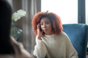 young woman in office setting discusses with mental health professional about picking the right psychiatrist in Alexandria, VA.