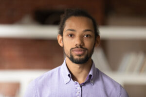 A man is looking straight on and is considering how his mental health affects his physical health.